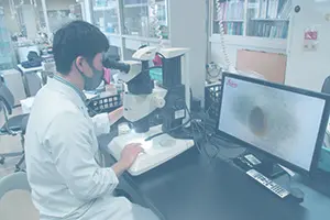 白衣を着た作業者が検査をしている様子